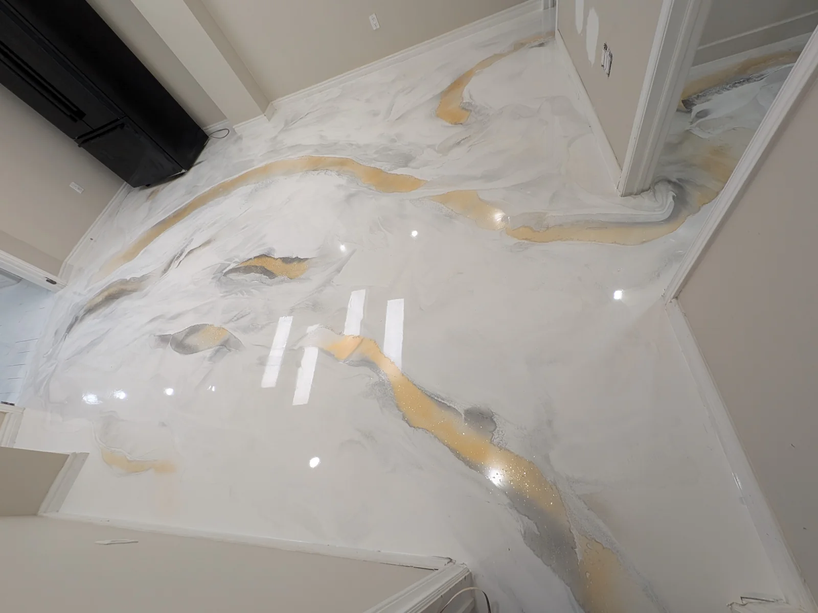 White metallic epoxy floor with flowing grey and gold veining in a Yamo project